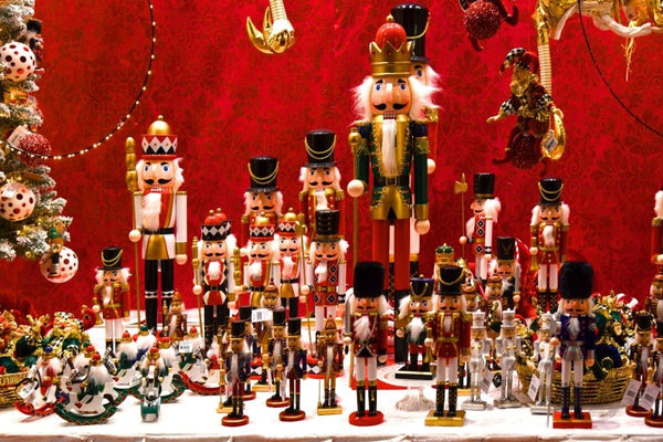 Collection of nutcracker dolls against a red backdrop.