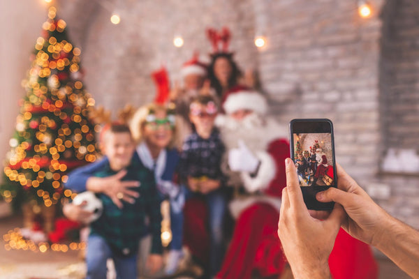 Family taking a selfie in front of a Christmas tree.