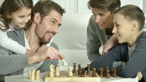 en familj spelar schack tillsammans