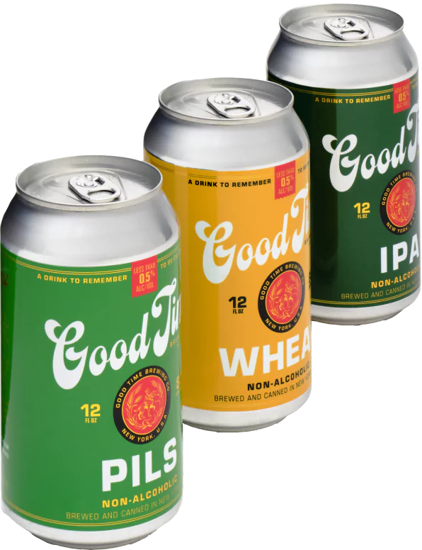 A line of three 'Good Time Non Alcoholic' beers. At the front is a 'Good Time Pils Non Alcoholic Beer', next is a 'Good Time Wheat Non Alcoholic Beer', and the furthest away from the camera is a 'Good Time IPA Non Alcoholic Beer'.