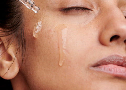 A woman using bakuchiol face serum.