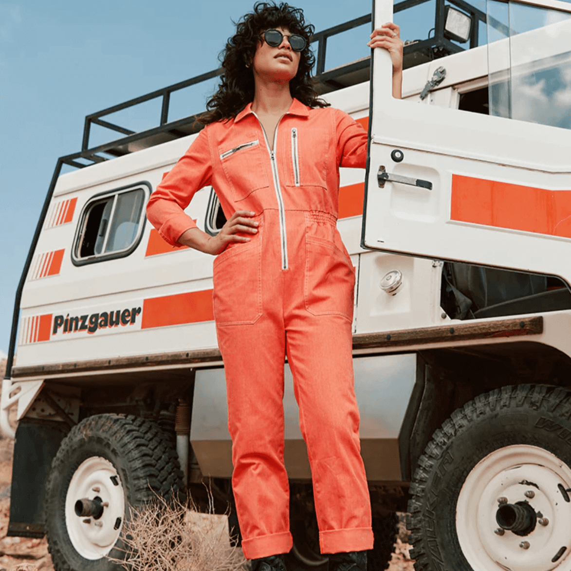 Atwyld Cadet Jumpsuit Female Model Relaxed Leaning on Classic Camper