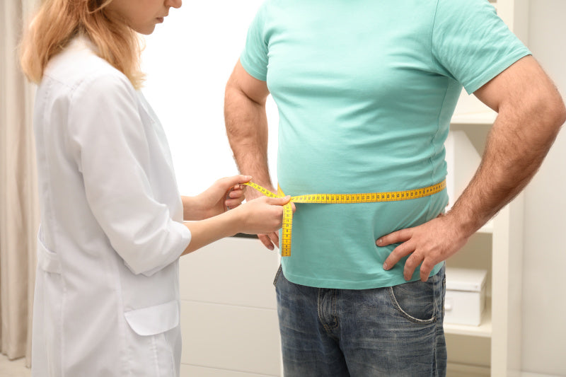 Medico donna misura il girovita di un uomo obeso