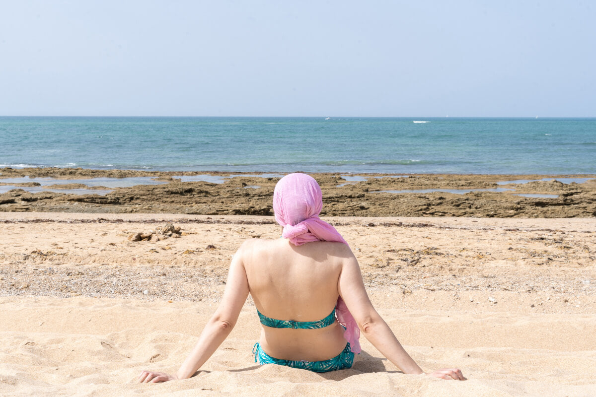 Donna in chemioterapia si gode il sole in spiaggia