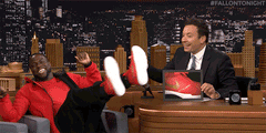 jimmy fallon guest in red jacket clicking feet together in the air