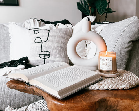 Wicks & Co. Candle next to sofa and book