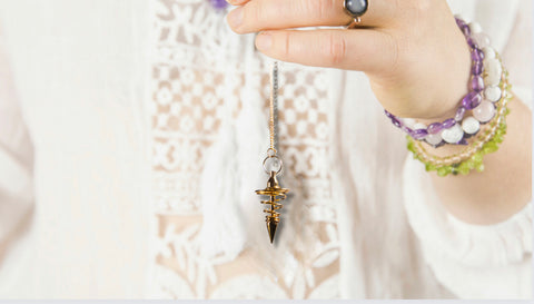 woman holding pendulum for divination