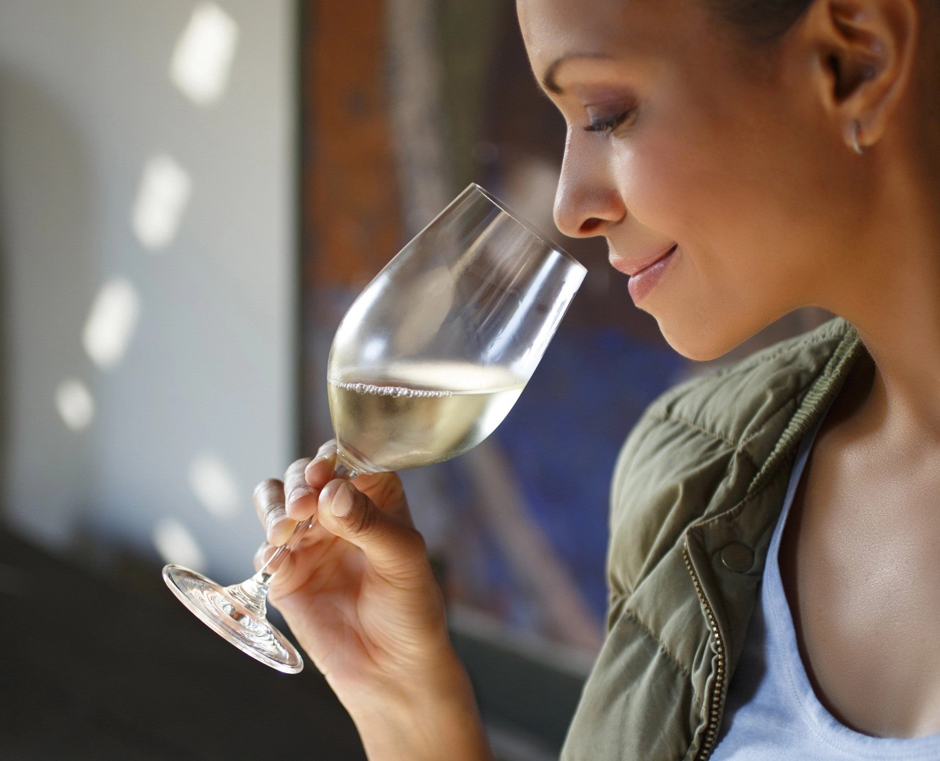 A woman smelling a glass of Riesling wine