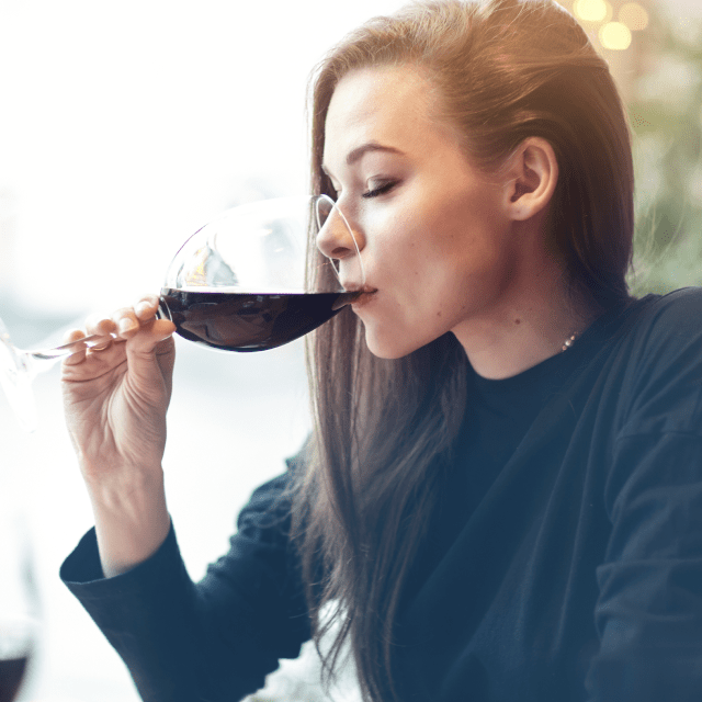 Woman tasting a glass of red wine