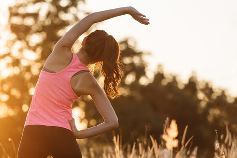 Healthy young woman warming up exercising outdoors