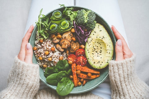 Woman holding plate with vegan or vegetarian food healthy diet