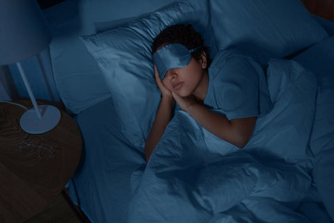 young african american woman in eye mask sleeping in bed at home at night restful sleep concept