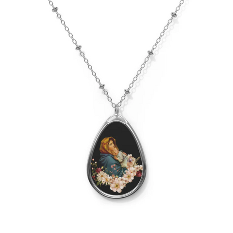 Mary holding baby Jesus in her arms, depicted on an oval necklace. A symbol of love, faith, and motherhood.