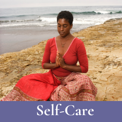 African American woman in red sari doing Namaste pose