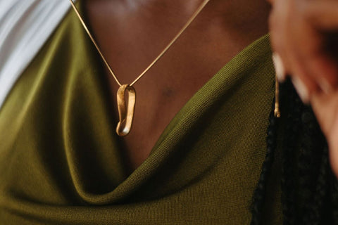 woman holding gold Mobius necklace