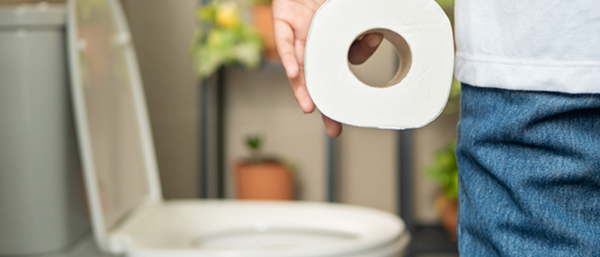 man in bathroom with toilet paper