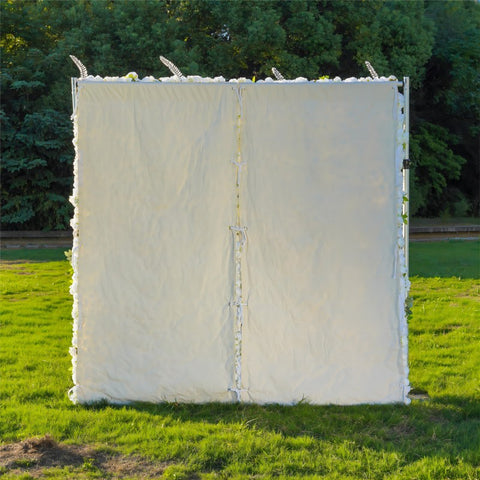 The white champagne fabric flower wall is fixed to a white cloth.