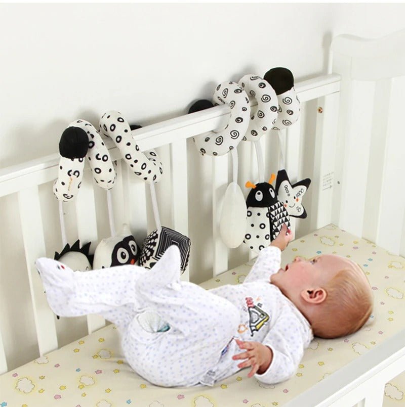 Bébé sur le dos essai d'atteindre la coccinelle de sa spirale d'activité.