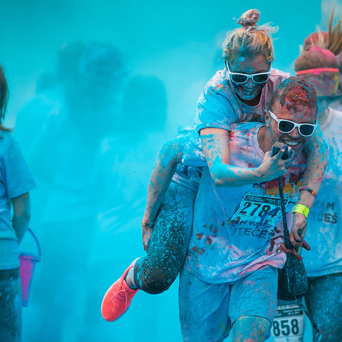 A couple running together through blue Colour Powder