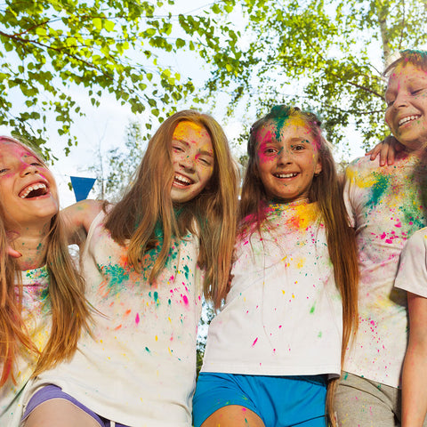 des enfants jouant avec de la poudre de couleur lors d'un événement scolaire