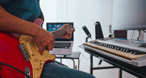 a musician recording electric guitar in digital system