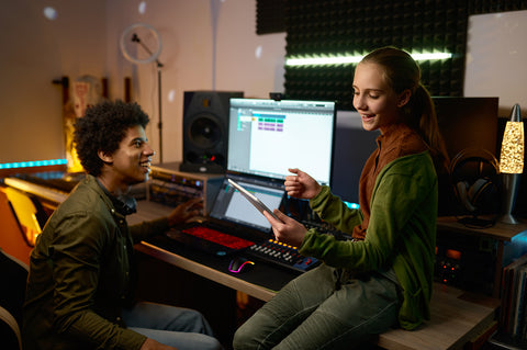 audio engineer with young singer working in music studio
