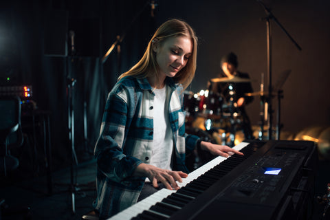 A girl playing the synthesizer music creation in a studio