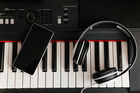 headphones and smartphone on musical synthesizer keyboard