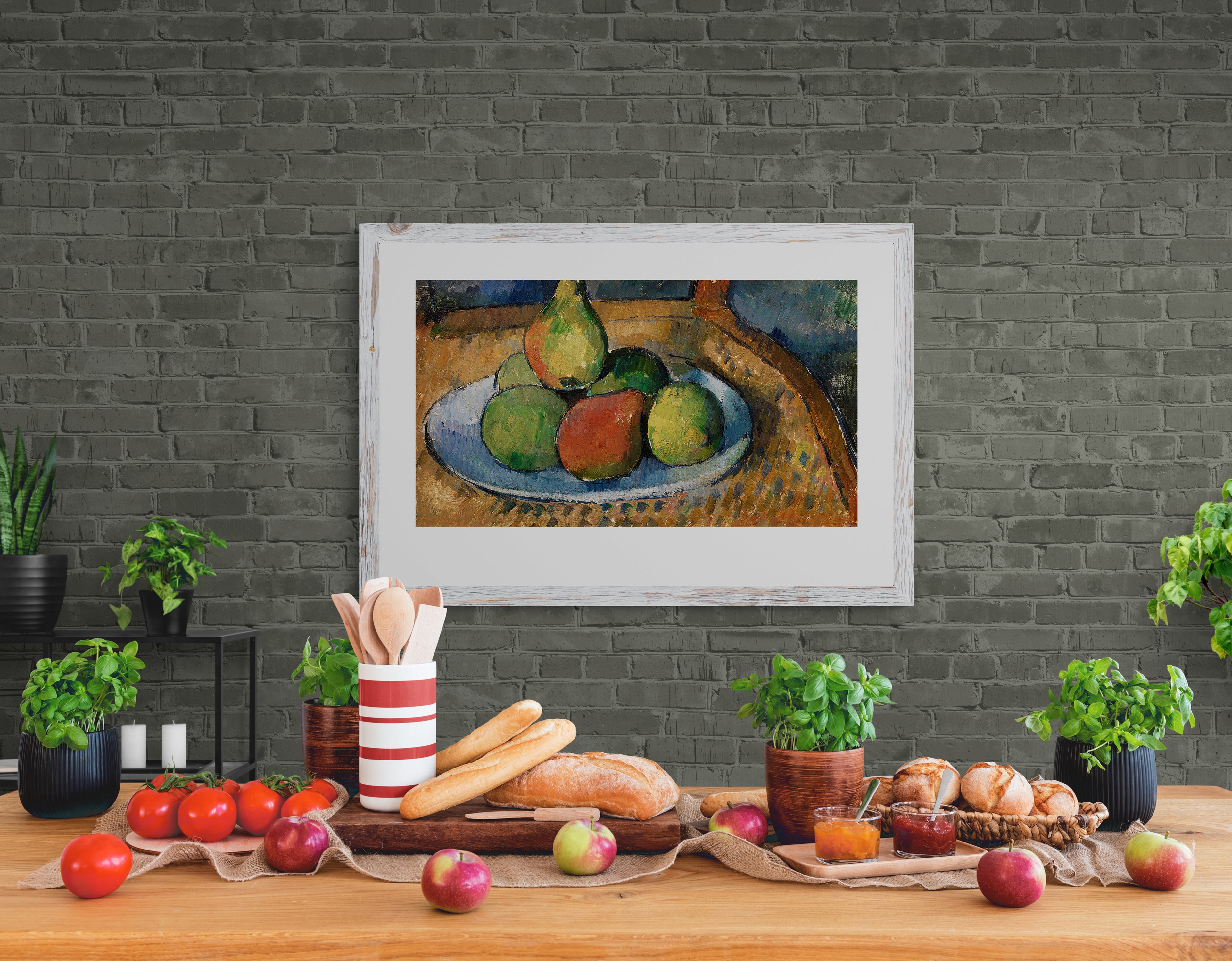 Rustic kitchen with green brick wall, a still-life painting of pears, a wooden countertop adorned with bread, tomatoes, and fresh herbs.