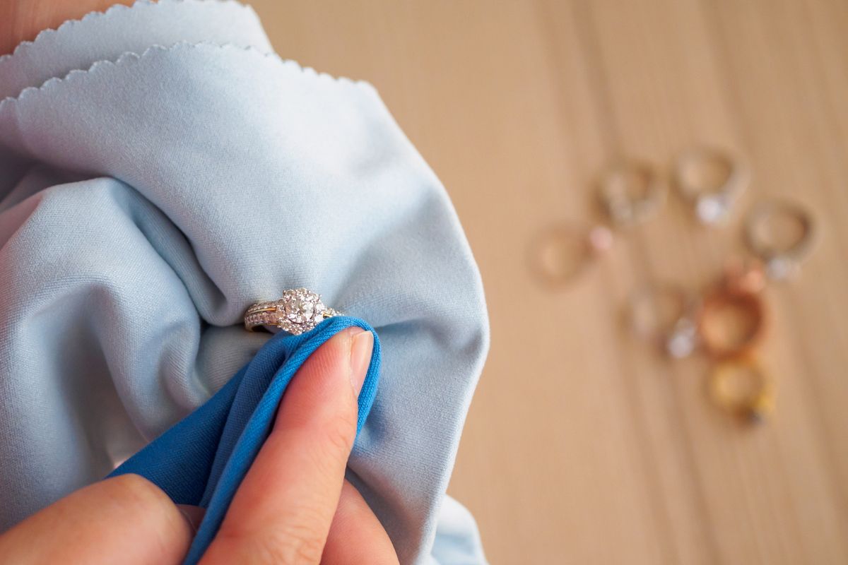 A lady cleaning her diamond ring with soft cloth.