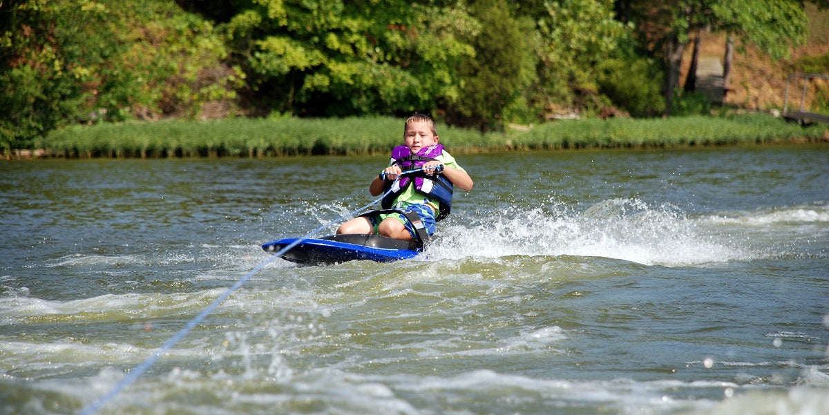 child kneeboarding on water