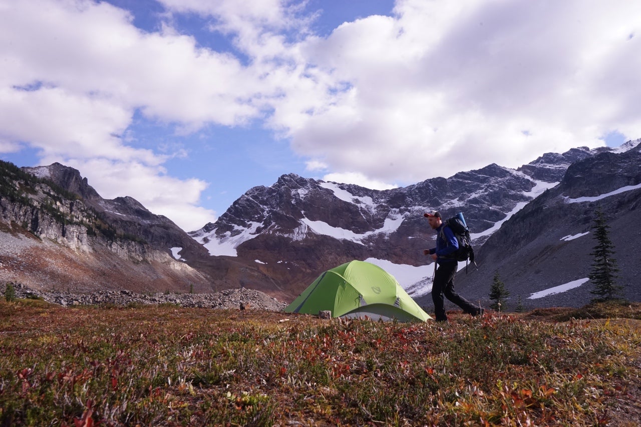 A person hikes to a tent