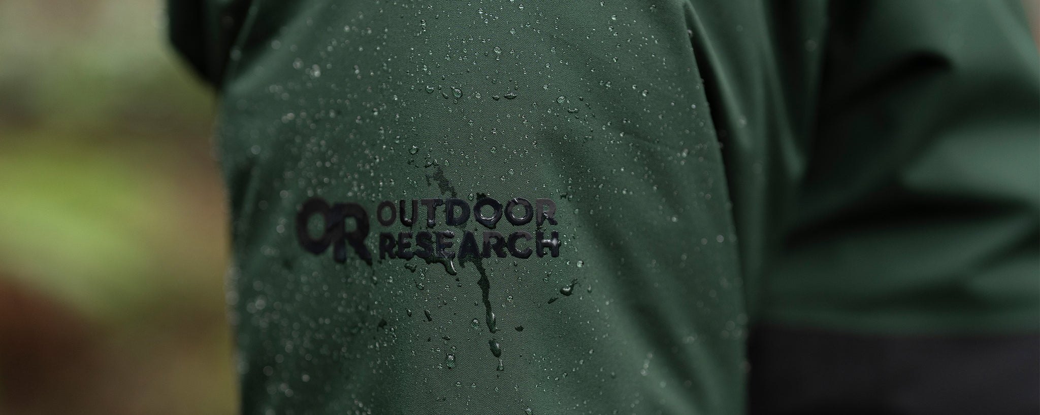 A close up of an Outdoor Research GORE-TEX jacket with beads of water.