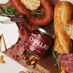 challas jar on charcuterie bard with meats and bread