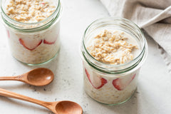 overnight oats in two jars with strawberries submerged