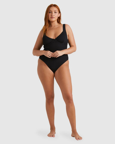 Red-haired model wearing the Billabong Summer High Chloe one piece swimwear in black