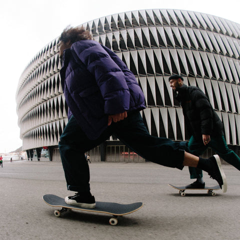 Pair of skateboarders skating together through a city