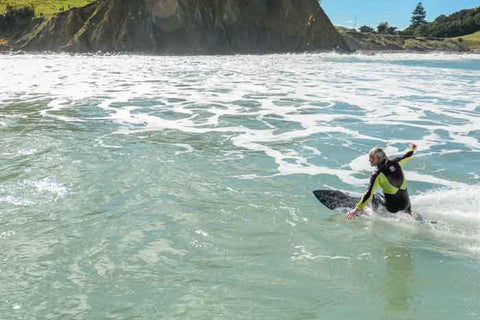 Image of local surf Stephan "Teddy" Colbert surfing on his back hand at Sponge Bay taken from the water