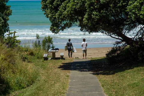 Photo showing the path down to the Stoockroute surf break at Wainui Beach in Gisborne and someone standing there with a snapped in half surfboard