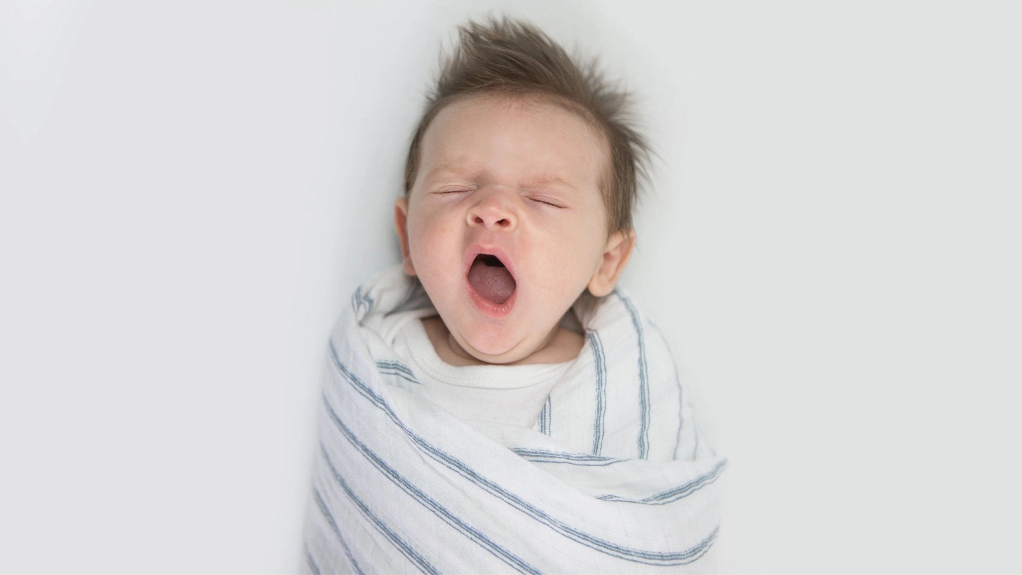 swaddled baby yawns