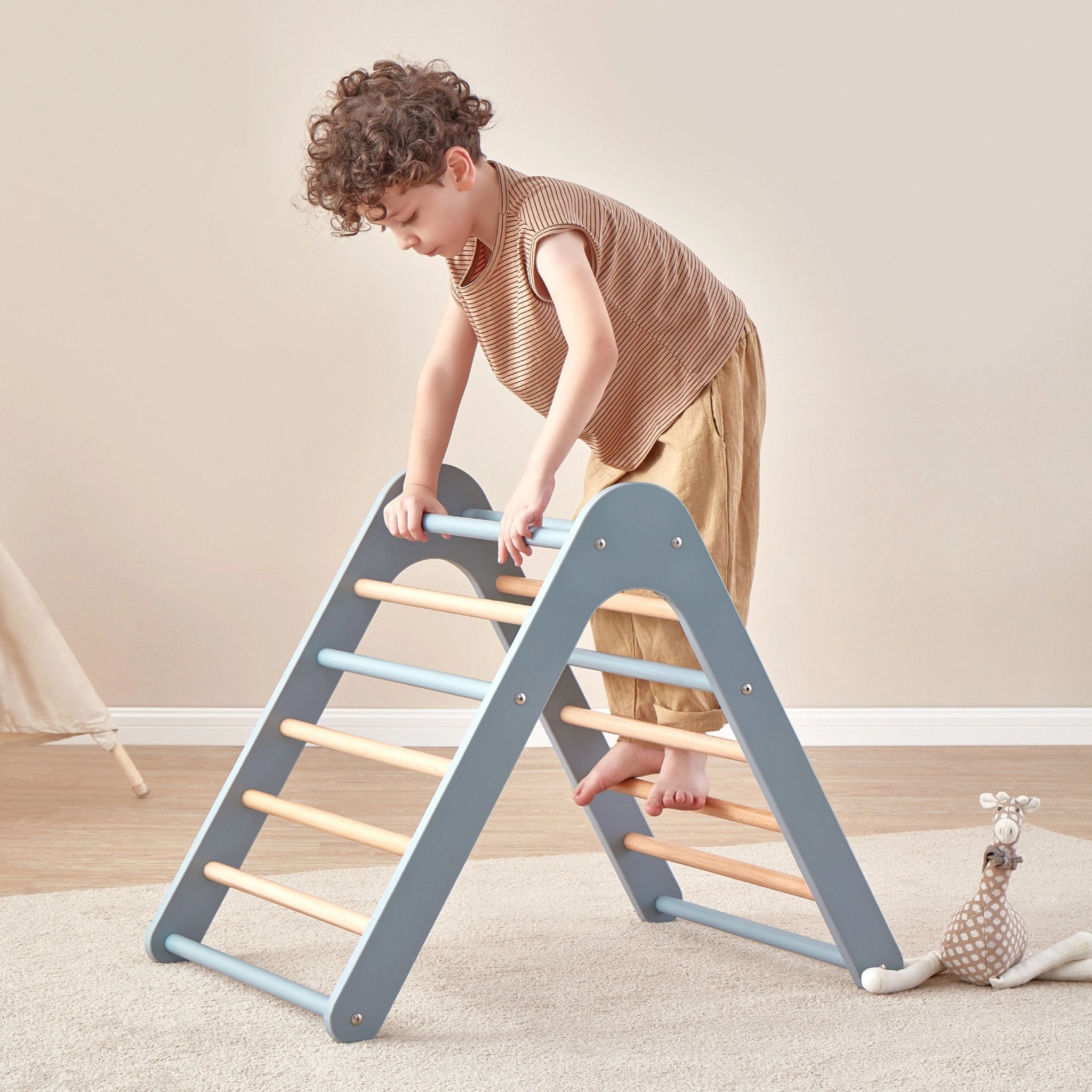 boy climbs blue climbing triangle