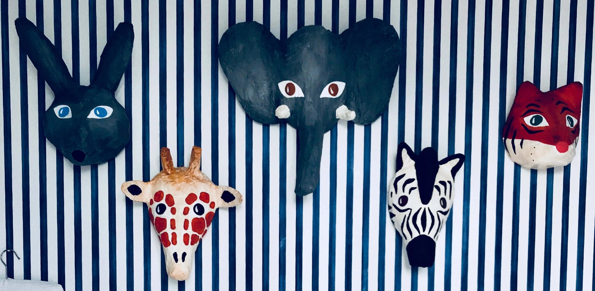 papier mache animal heads on blue striped wall