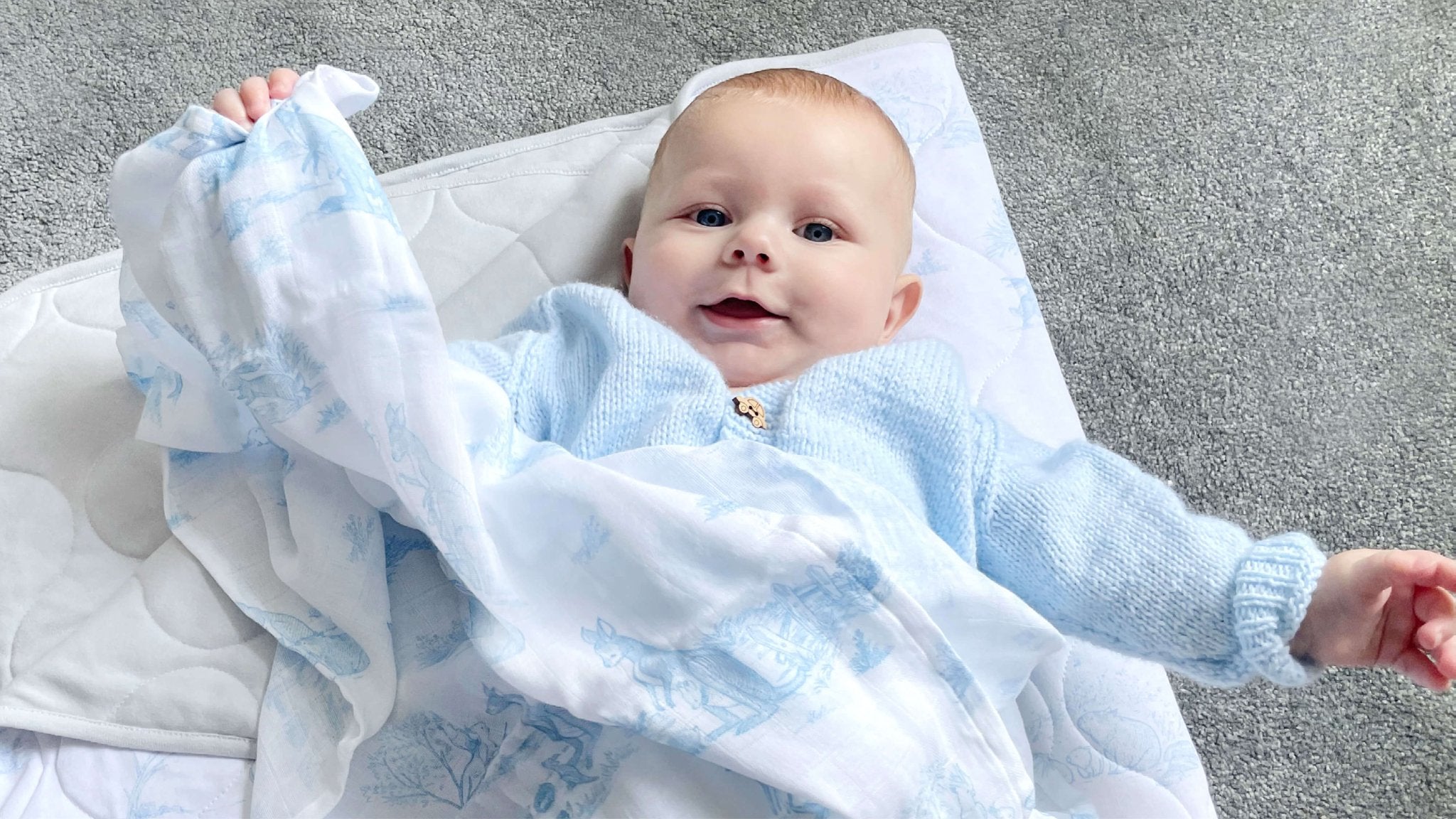 happy baby plays with muslin cloth