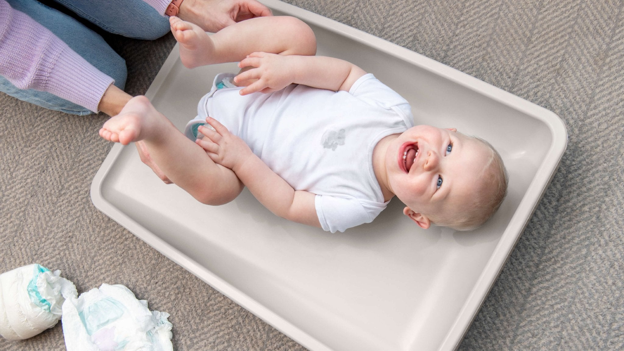 baby laughing while laying on changing pad