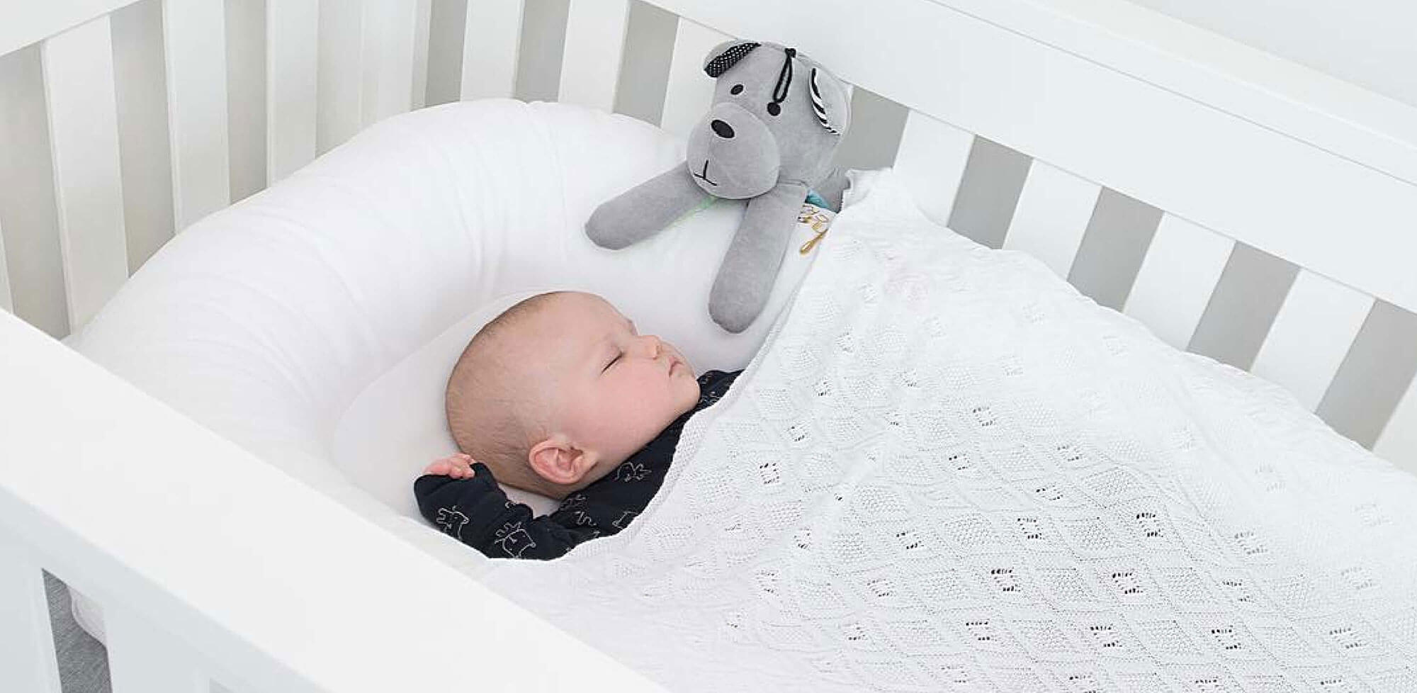 Baby sleeping in white Eton Convertible Plus Cot Bed