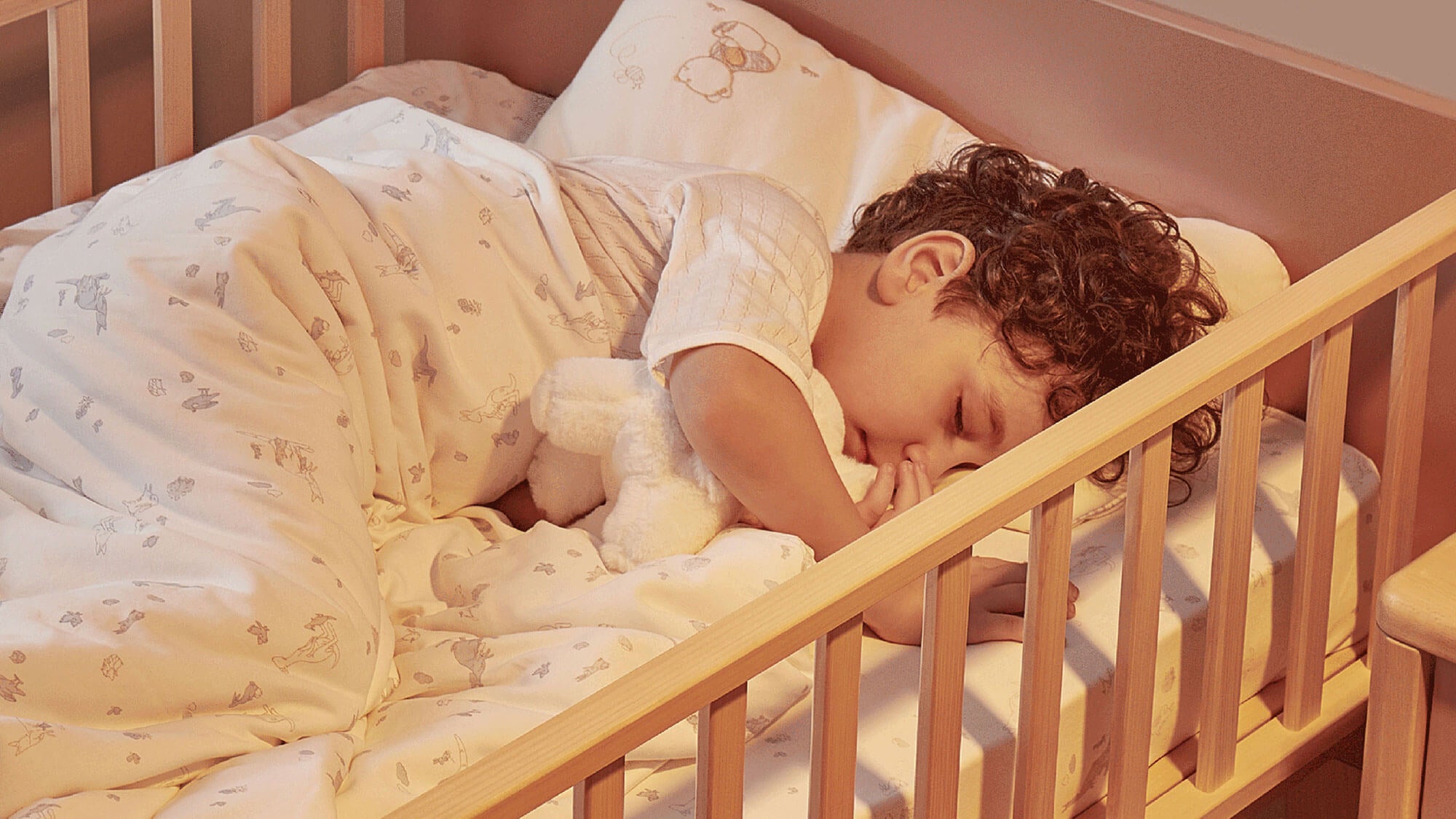 Little boy asleep in Natty Bedside Bed