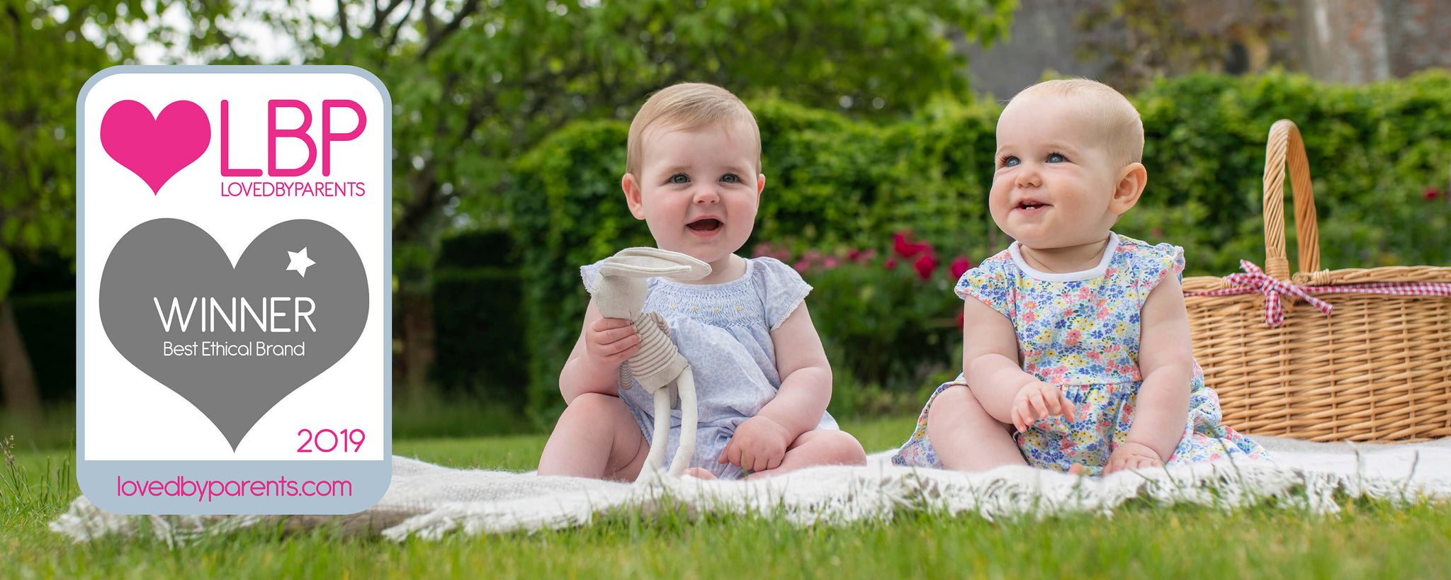 Babies sat on the grass with a Best Brand Loved by Parents award