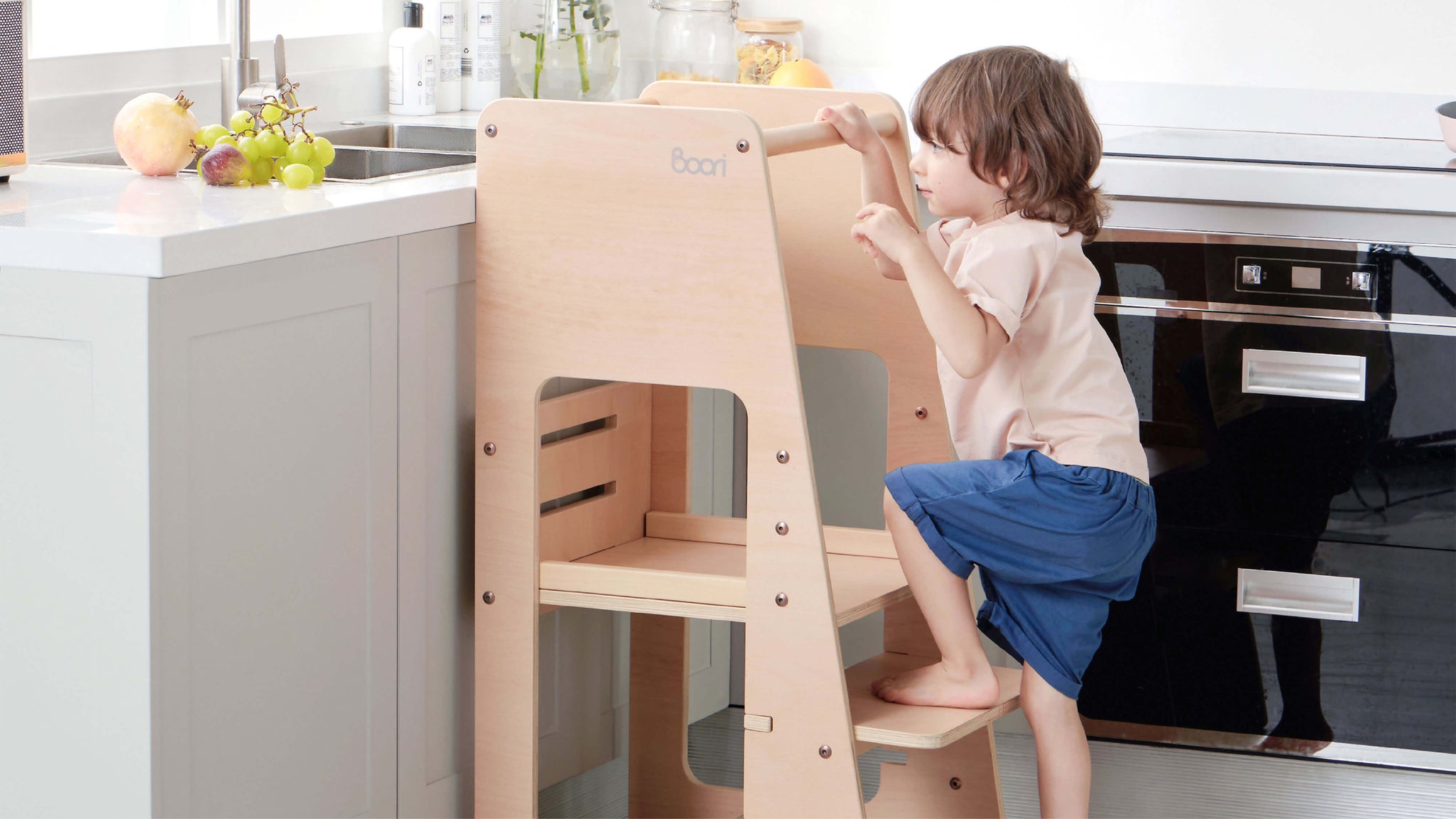 Child using Learning Tower to reach sink