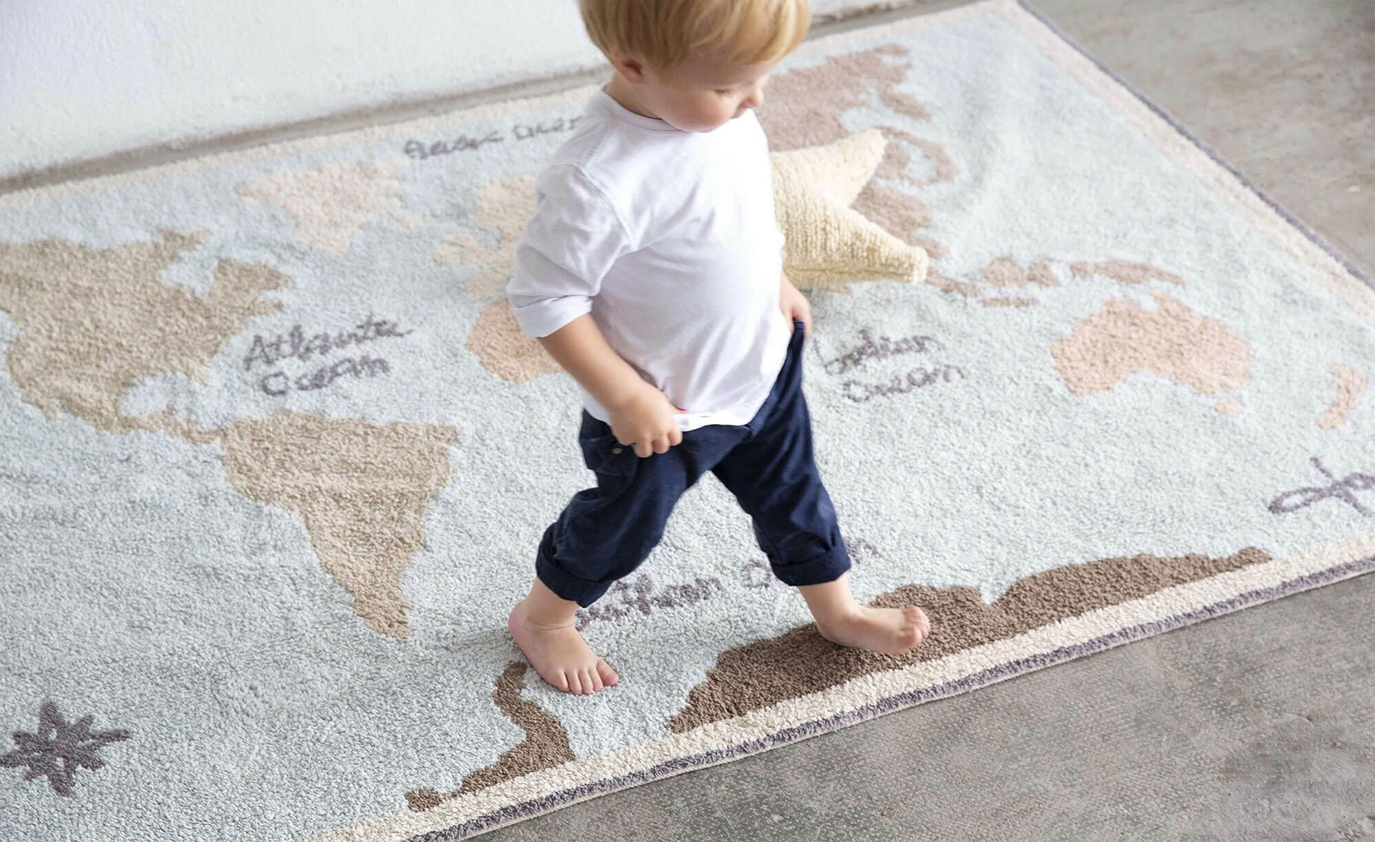 Little boy walking on map rug