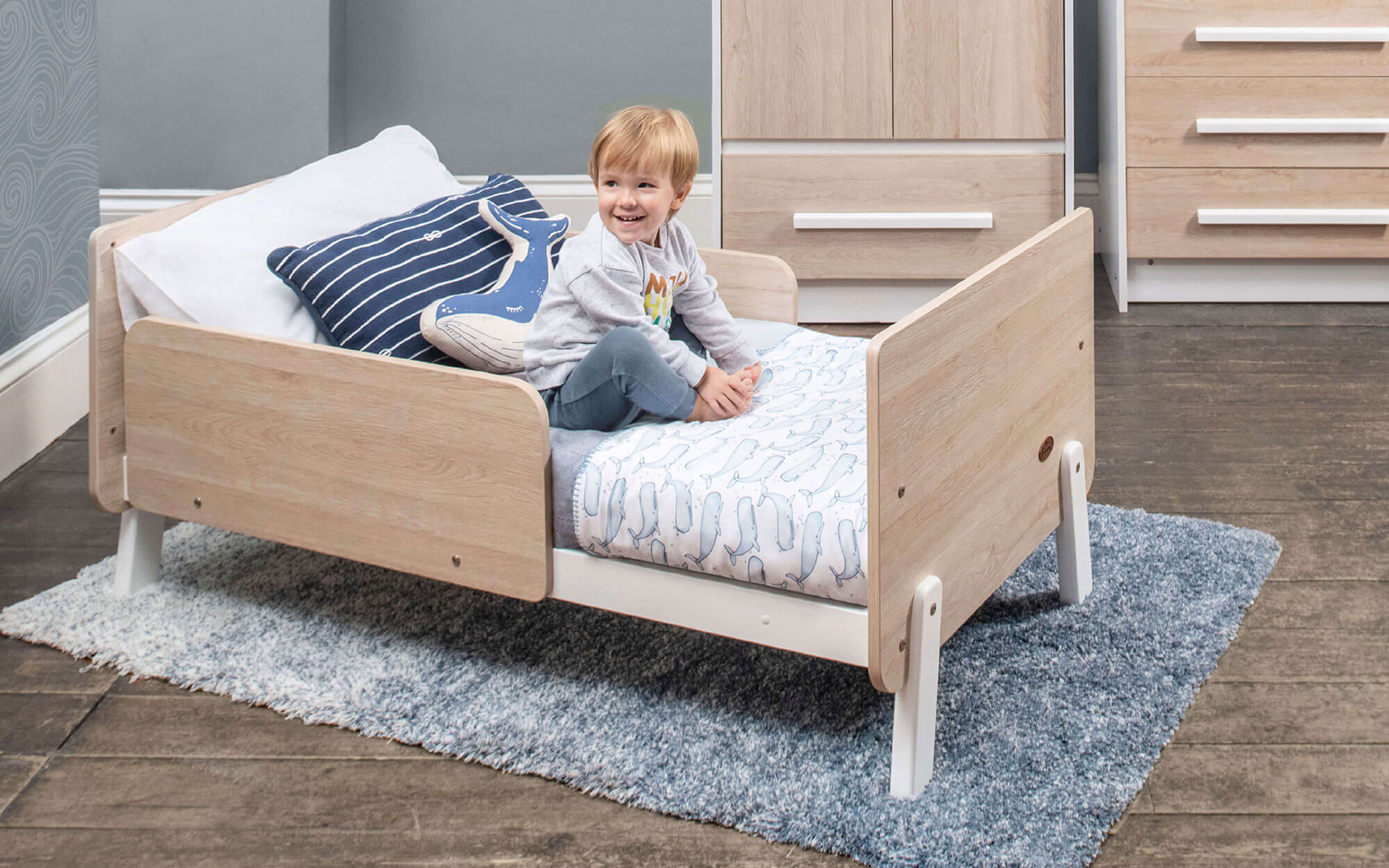 Toddler in toddler bed with guard panel